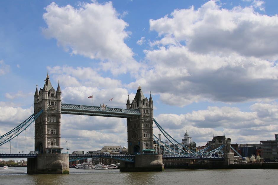 A view of a green and yellow painted bridge spanning across the River Thames in central London, with stone piers and decorative lampposts lining the walkway. The bridge's architecture features multiple arches supported by stone columns, and in the background, historic and modern buildings with spires and domes are visible under a cloudy sky. This scene relates to the typical relocation environment for house removals, where furniture and boxes might be loaded onto vehicles for moving within or near Southwark, London. The image does not show any furniture or people, but the setting implies an urban moving context supported by companies like Man and Van Southwark, focusing on efficient transport and home relocation logistics in the area.